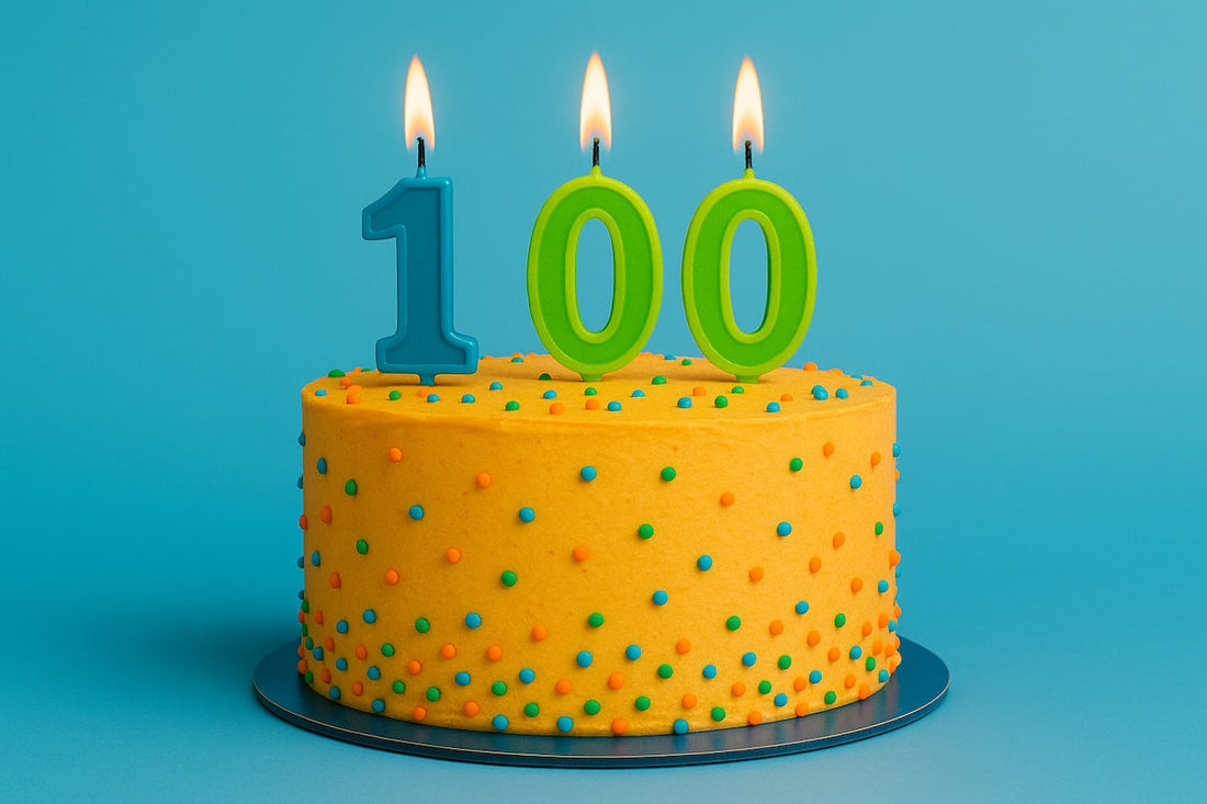Colorful 100th birthday cake with lit candles symbolizing longevity and healthy aging celebration.