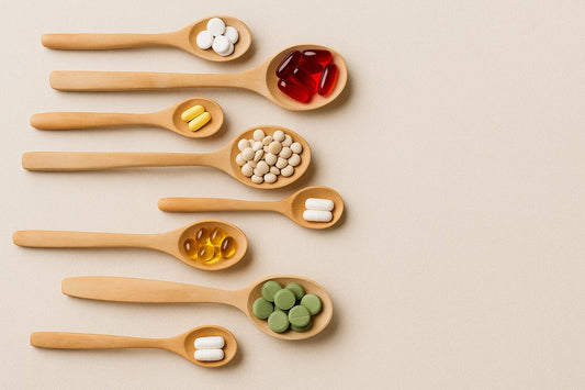 Wooden spoons displaying various vitamins and supplements on a neutral background for nutrition and wellness.