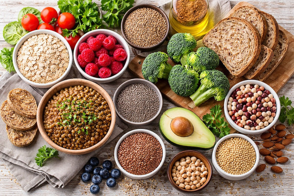 Top high-fiber foods including oats, lentils, chia seeds, broccoli, avocado, and berries arranged on a rustic table.